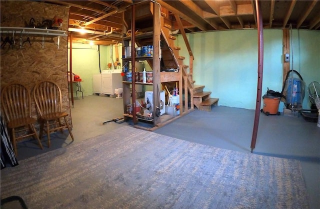 unfinished below grade area featuring washing machine and dryer and stairway