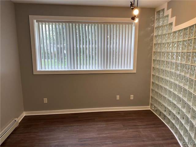 unfurnished room featuring baseboards, dark wood-style flooring, and a baseboard radiator