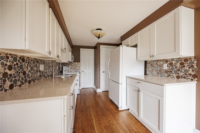kitchen with wood finished floors, white cabinets, and backsplash