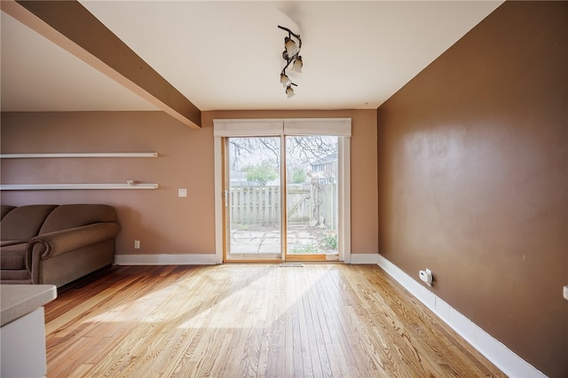 doorway featuring light wood-style floors, baseboards, and track lighting