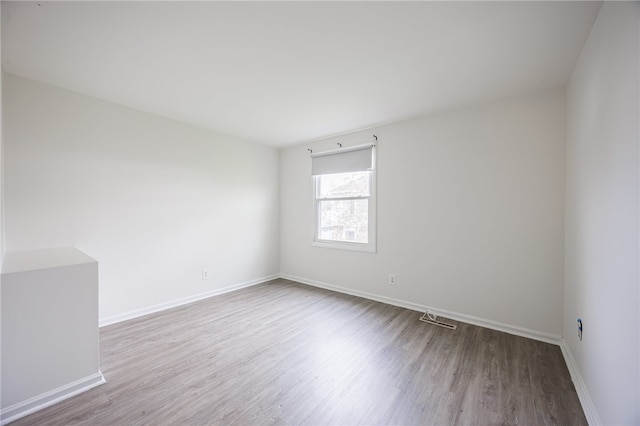 empty room featuring wood finished floors and baseboards