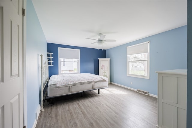 bedroom with wood finished floors, baseboards, and a ceiling fan