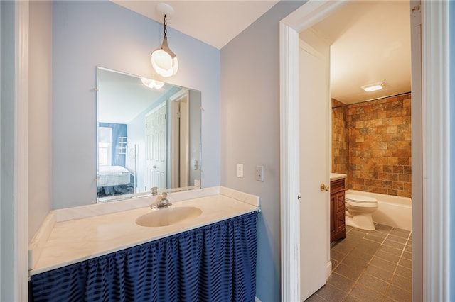 full bathroom featuring vanity, ensuite bathroom, tile patterned flooring, toilet, and washtub / shower combination
