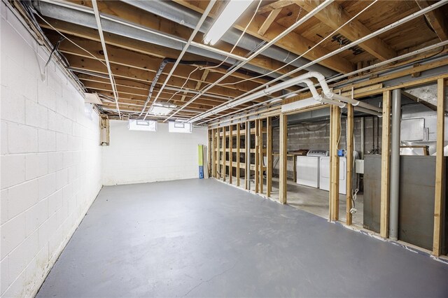 basement featuring washer and clothes dryer and concrete block wall