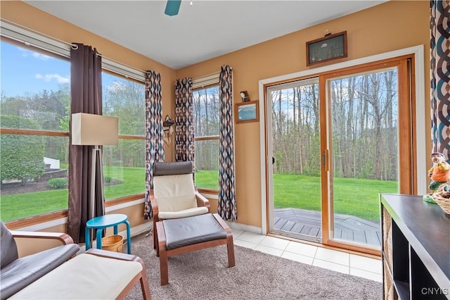 doorway to outside with tile patterned floors, baseboards, a ceiling fan, and carpet