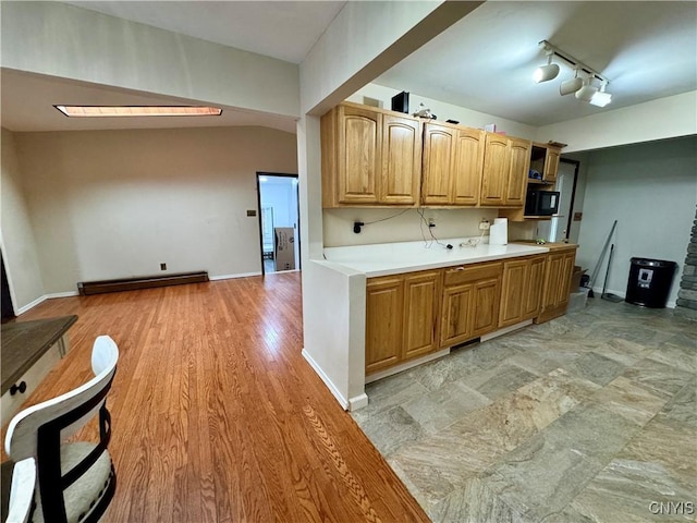 107 Birchwood Ln, Frankfort, NY 13340 - kitchen with rail lighting, baseboards, light countertops, light wood-style floors, and a baseboard radiator