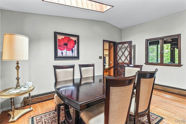 107 Birchwood Ln, Frankfort, NY 13340 - dining area with baseboards, wood finished floors, and lofted ceiling with skylight