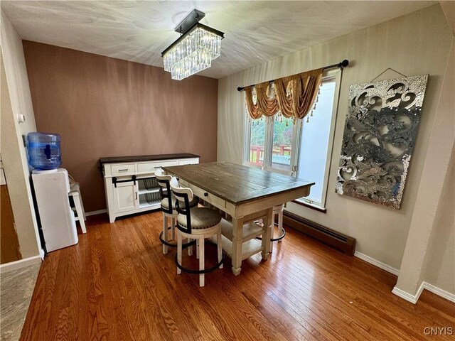 107 Birchwood Ln, Frankfort, NY 13340 - dining area featuring baseboards, a chandelier, wood finished floors, and a baseboard radiator