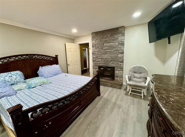 107 Birchwood Ln, Frankfort, NY 13340 - bedroom featuring crown molding, light wood-style flooring, and a fireplace
