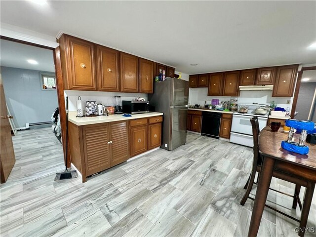 107 Birchwood Ln, Frankfort, NY 13340 - kitchen with brown cabinets, under cabinet range hood, light wood-style flooring, light countertops, and appliances with stainless steel finishes