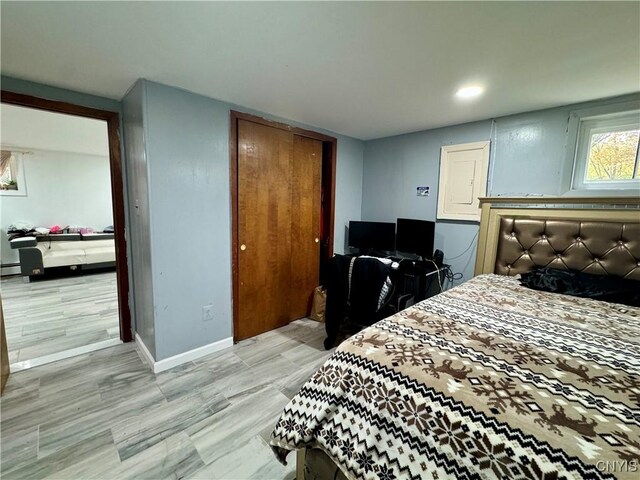 107 Birchwood Ln, Frankfort, NY 13340 - bedroom featuring a closet, light wood-style floors, baseboards, and a baseboard radiator