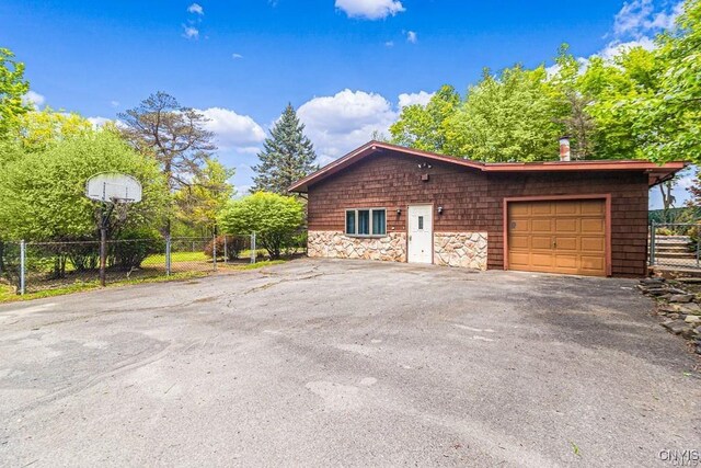 107 Birchwood Ln, Frankfort, NY 13340 - view of side of home featuring stone siding, an attached garage, a chimney, fence, and aphalt driveway