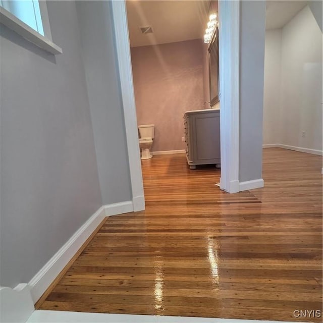 interior space with baseboards, hardwood / wood-style floors, and visible vents