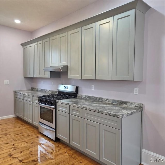 kitchen with stainless steel range with gas cooktop, gray cabinetry, and under cabinet range hood