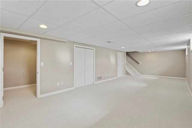 finished below grade area featuring a drop ceiling, recessed lighting, and carpet