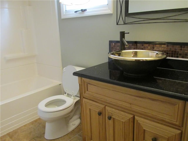 bathroom with toilet, vanity, tile patterned floors, backsplash, and shower / bath combination
