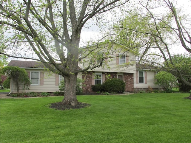 view of front of house with brick siding and a front lawn