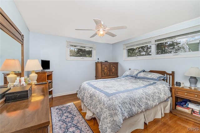 bedroom featuring a ceiling fan, wood finished floors, and baseboards