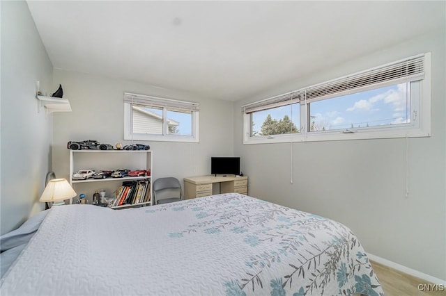 bedroom featuring light colored carpet and baseboards