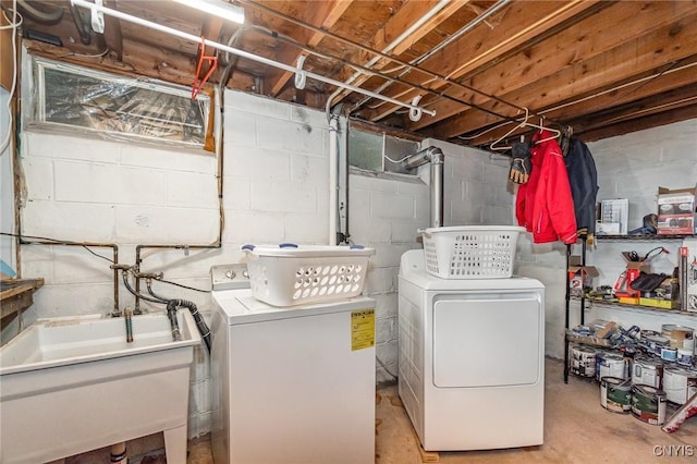 washroom with laundry area, washing machine and dryer, and a sink