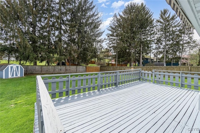 deck featuring a yard, an outdoor structure, a fenced backyard, and a storage unit