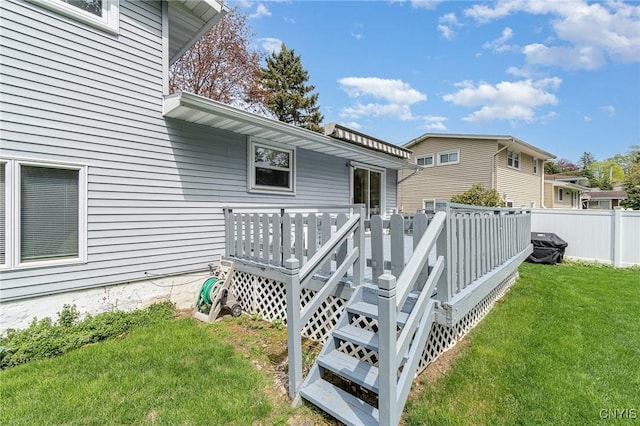 wooden deck featuring a yard and fence
