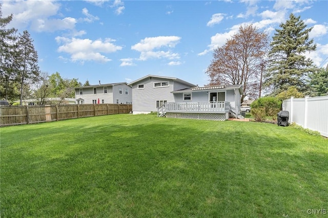 back of house with a lawn, a wooden deck, and a fenced backyard