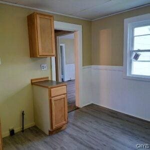 1011 Irving St, Olean-City, NY 14760 - unfurnished dining area with crown molding and dark wood-style floors