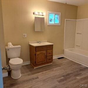 1011 Irving St, Olean-City, NY 14760 - bathroom featuring vanity, toilet, baseboards, and wood finished floors