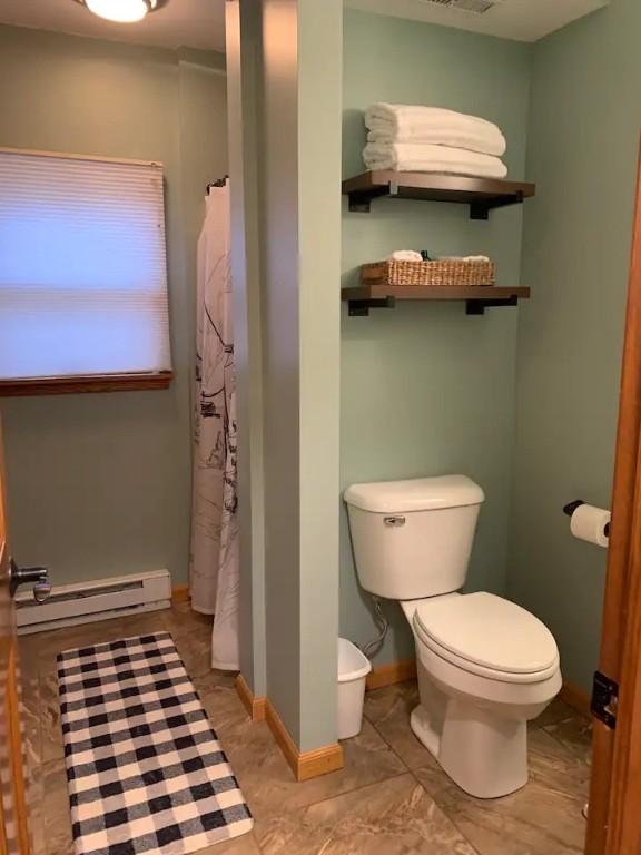 7136 Maples Rd, Mansfield, NY 14755 - bathroom with a baseboard radiator, toilet, a shower with curtain, and baseboards