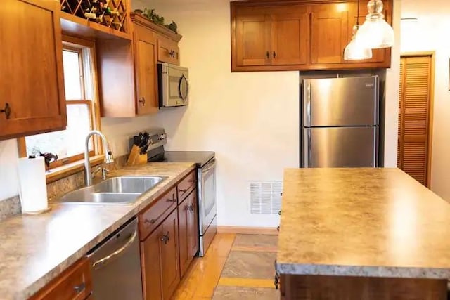 7136 Maples Rd, Mansfield, NY 14755 - kitchen with appliances with stainless steel finishes, visible vents, brown cabinetry, and a sink