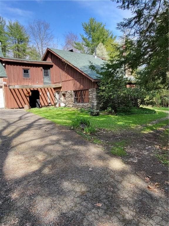607 Kilkenny Rd, Unadilla, NY 13849 - view of home's exterior with stone siding, board and batten siding, a garage, and driveway