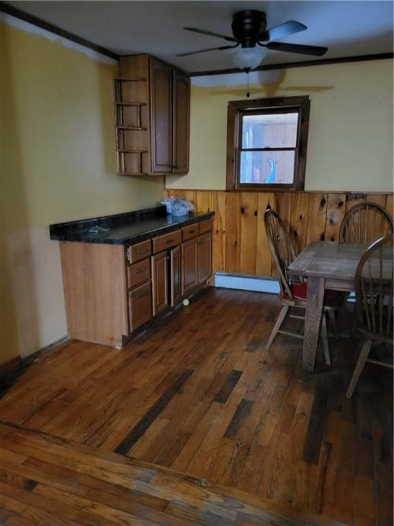 607 Kilkenny Rd, Unadilla, NY 13849 - dining area featuring a ceiling fan, wooden walls, wainscoting, and dark wood-style floors