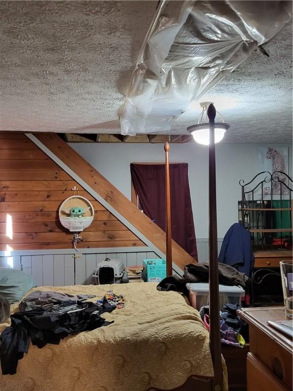 607 Kilkenny Rd, Unadilla, NY 13849 - bedroom featuring wooden walls and a textured ceiling