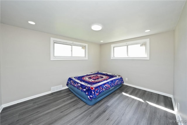 bedroom with baseboards, recessed lighting, visible vents, and wood finished floors