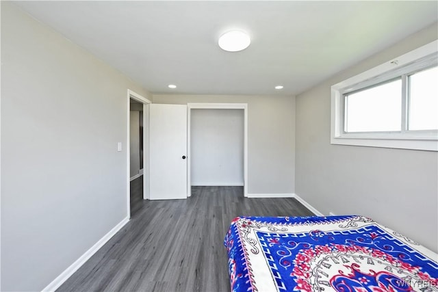unfurnished bedroom with recessed lighting, baseboards, a closet, and wood finished floors