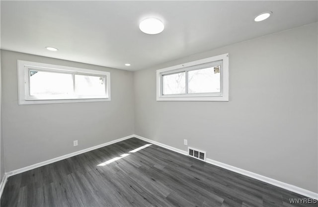 basement with recessed lighting, baseboards, visible vents, and dark wood finished floors