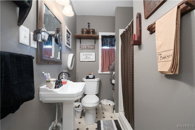 bathroom with toilet, curtained shower, and tile patterned floors