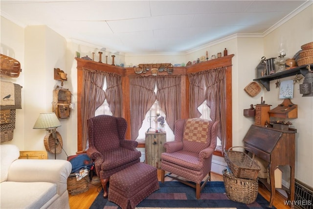 living area with wood finished floors and ornamental molding