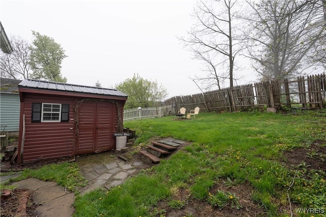 view of yard with an outdoor structure, a fenced backyard, and a shed