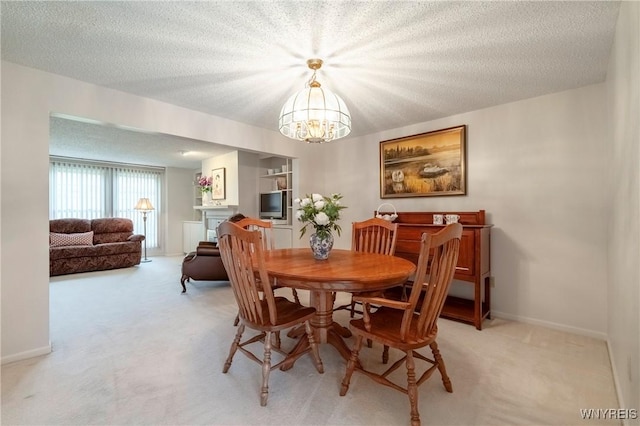 dining area featuring light carpet, a chandelier, baseboards, and a textured ceiling