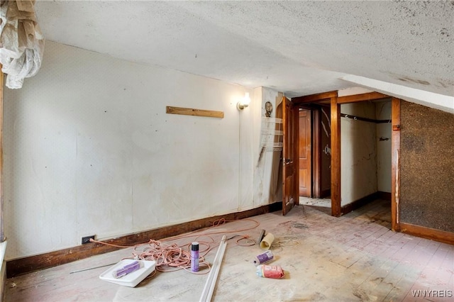 empty room featuring a textured ceiling and baseboards