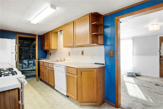 kitchen with white appliances, a sink, open shelves, light countertops, and wainscoting