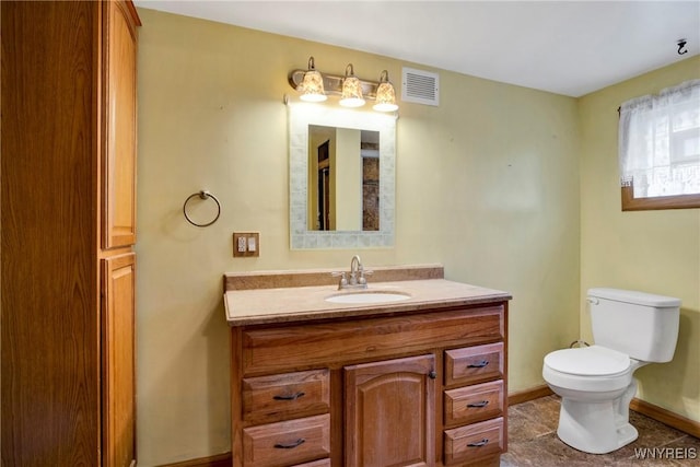 bathroom featuring toilet, vanity, and baseboards