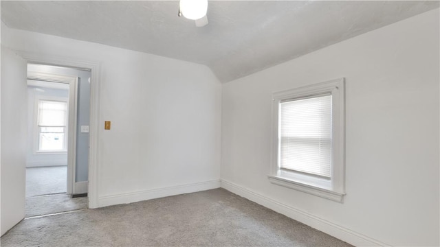unfurnished room with vaulted ceiling, carpet floors, and baseboards