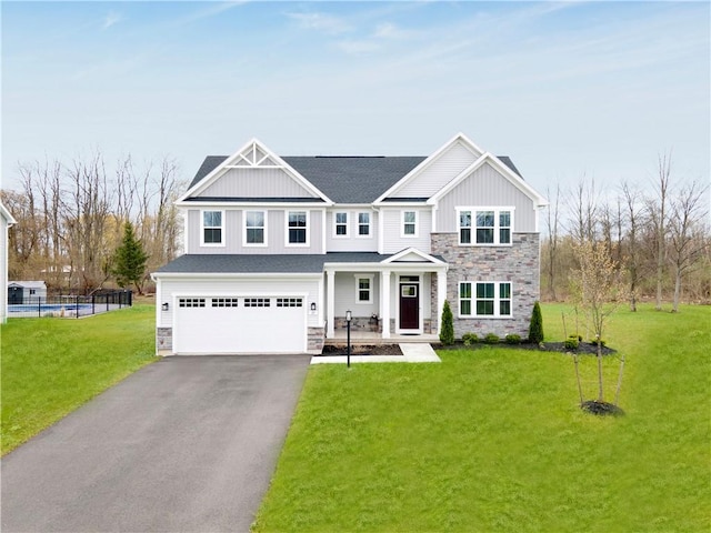 view of front of house featuring aphalt driveway, an attached garage, stone siding, a front lawn, and board and batten siding