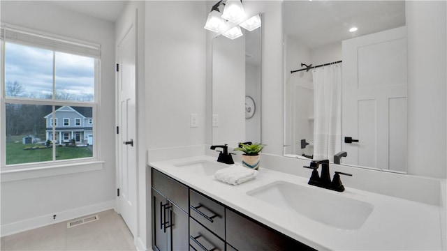 full bathroom with double vanity, visible vents, baseboards, and a sink