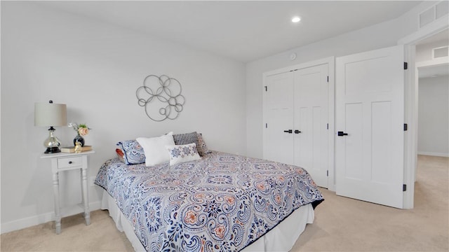 bedroom featuring light carpet, a closet, baseboards, and visible vents