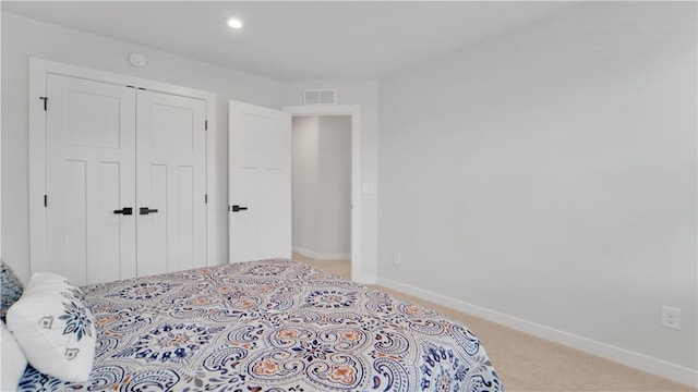 carpeted bedroom with a closet, visible vents, baseboards, and recessed lighting