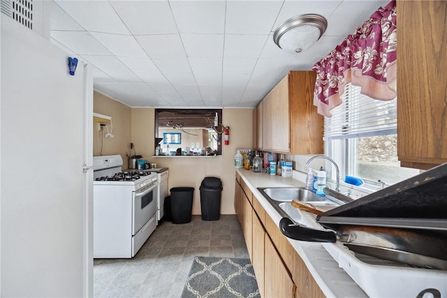 11519 E Lake Rd, Wayne, NY 14840 - kitchen with white gas range oven, a sink, light countertops, and a healthy amount of sunlight